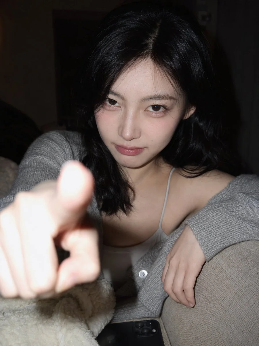 A Korean woman playfully pokes the camera lens with her finger