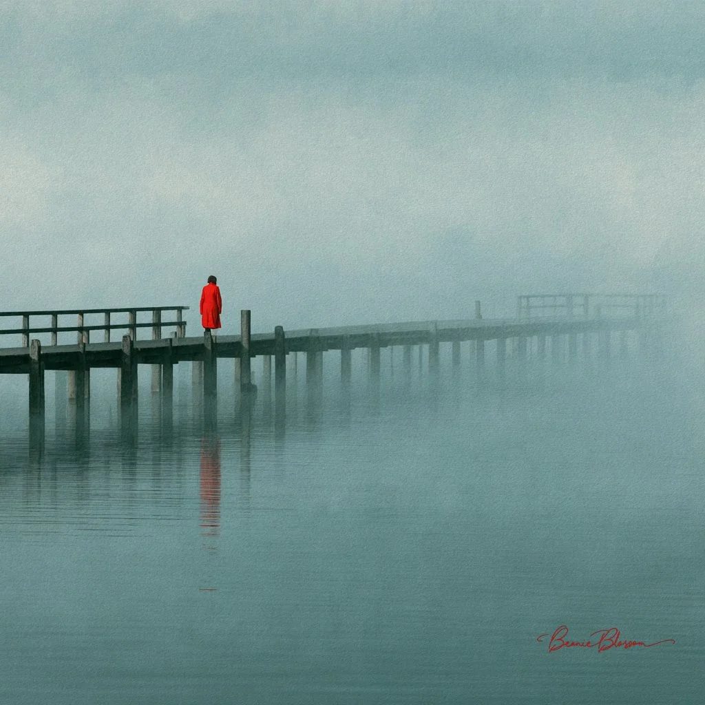 A lone woman in red walks into thick morning fog on a wooden pier