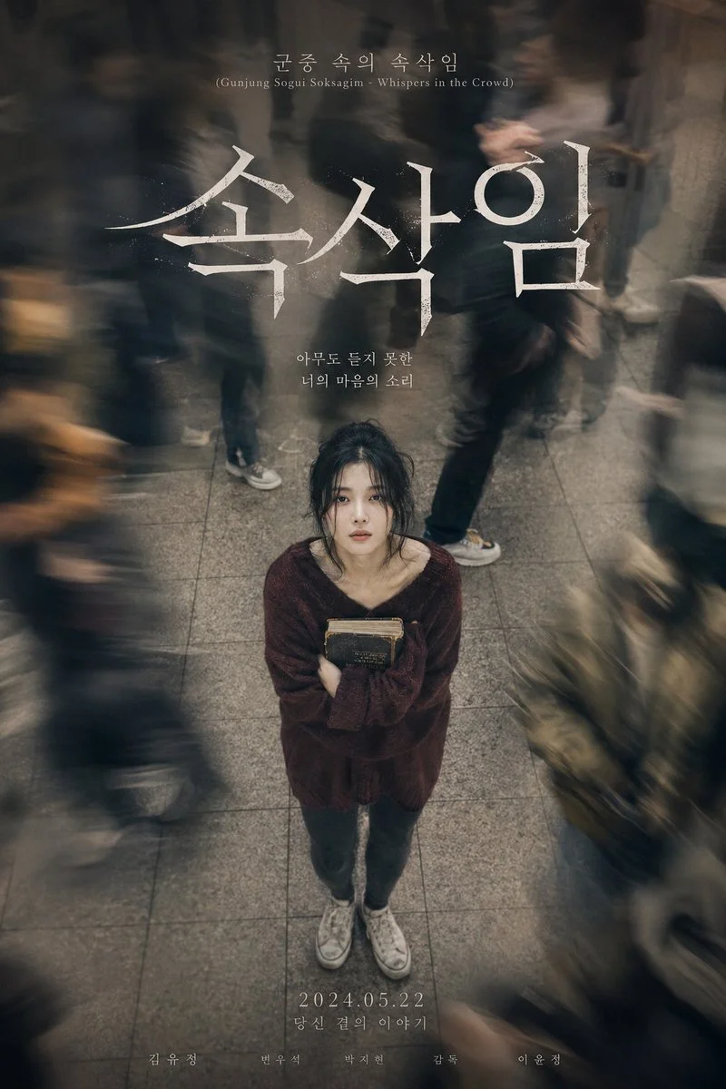 A lonely woman clutches a novel while commuters blur past her.