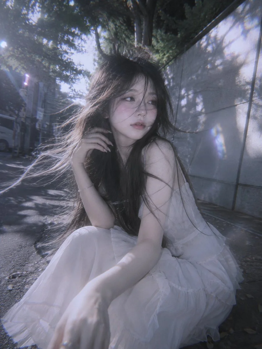 A shy doll-like woman feels the breeze in soft pastel tones