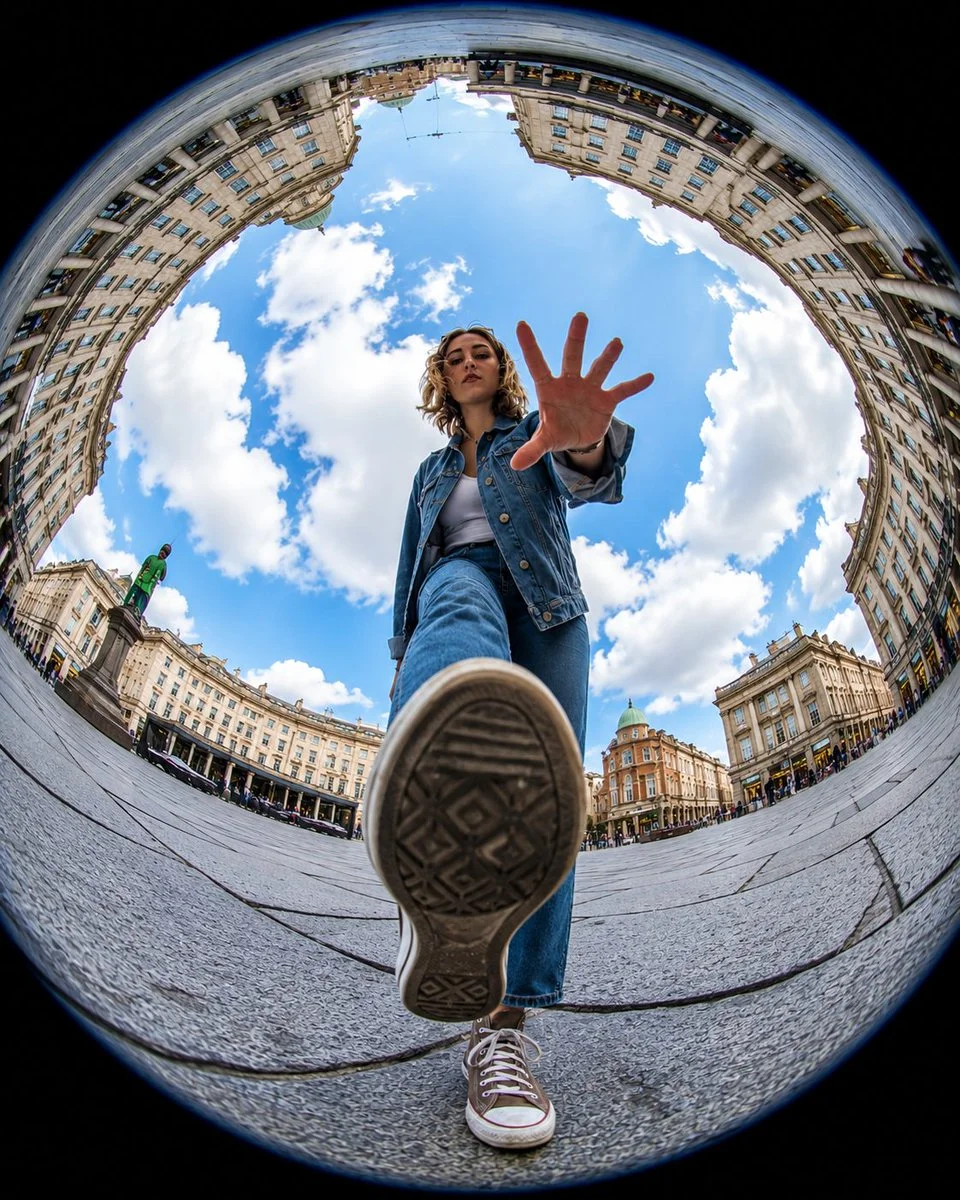 A sneaker dominates the foreground as a hand reaches toward the lens