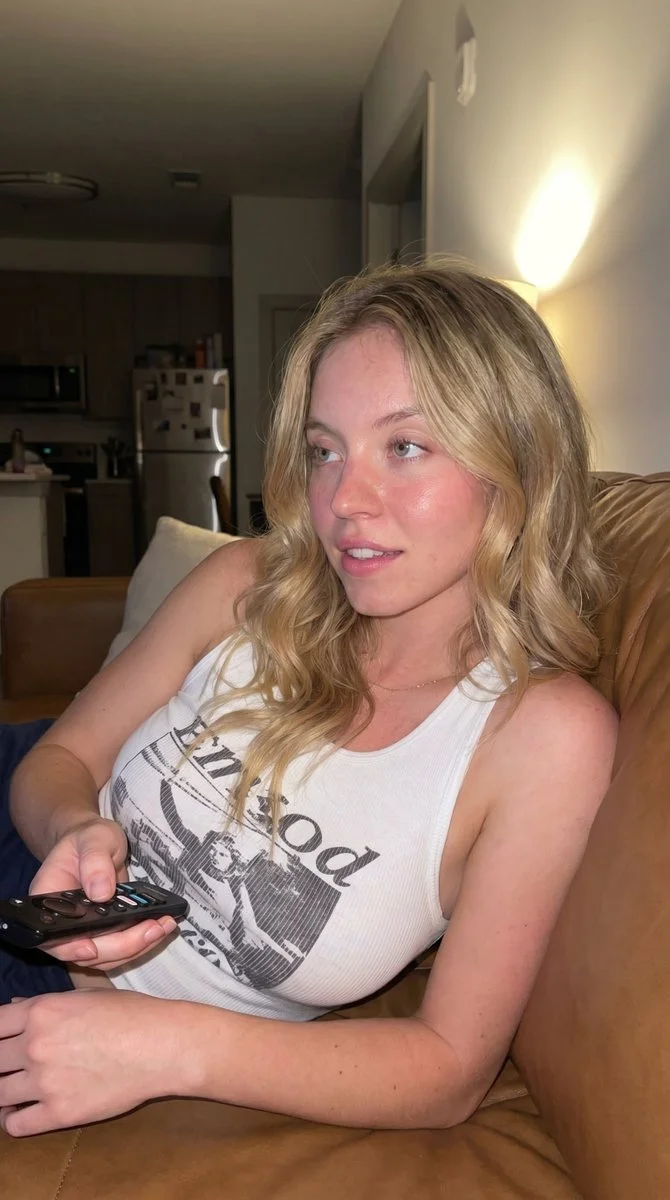 A woman reclines on a couch watching late night TV