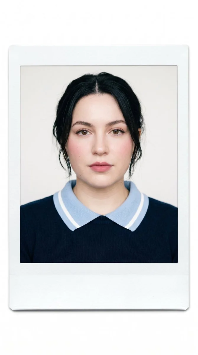 A young woman in navy sweater poses for minimalist portrait.