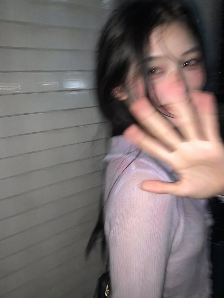 A young woman turns in surprise on a dark Tokyo street
