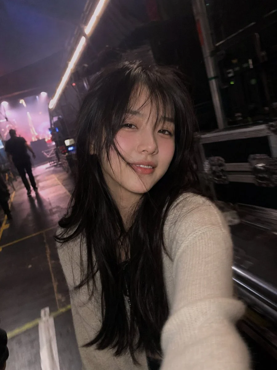 Backstage candid shows a tired performer with rosy blush and wind-tousled hair
