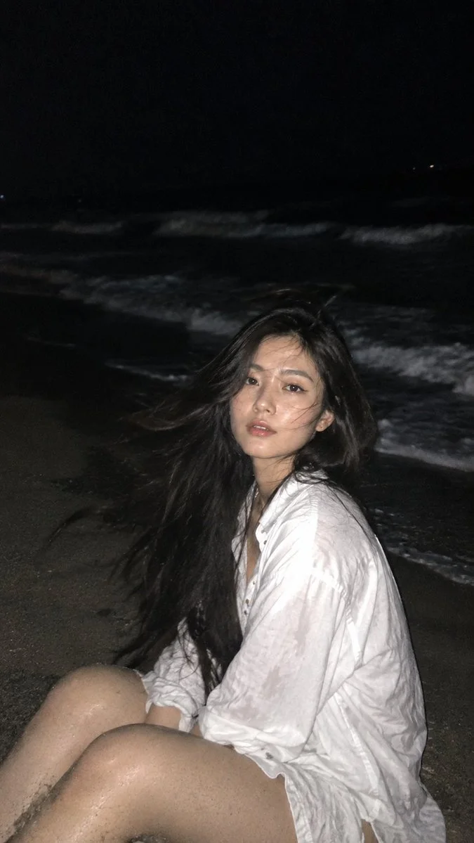 Candid Night Beach Portrait of Woman Brushing Windblown Hair