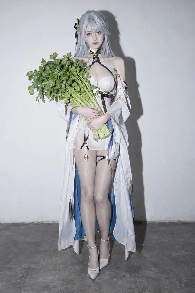 Cold adult cosplayer clutches fresh celery against stark white wall
