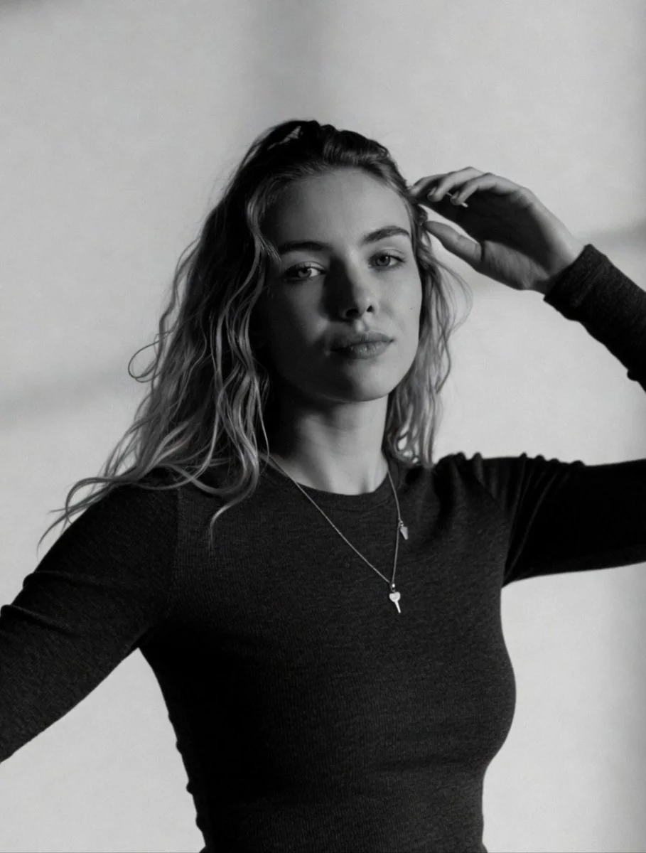 Confident blonde woman gazes directly into camera in classic style