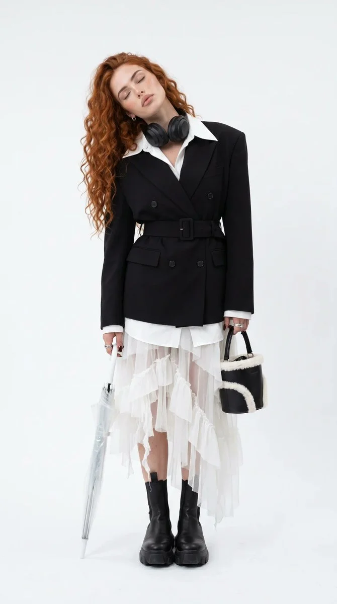Copper-haired model in avant-garde couture poses in white studio