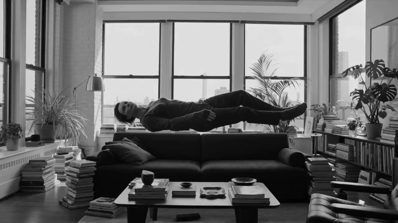 Calm Indoors, a Floating Figure Rotates by Sunlit Windows