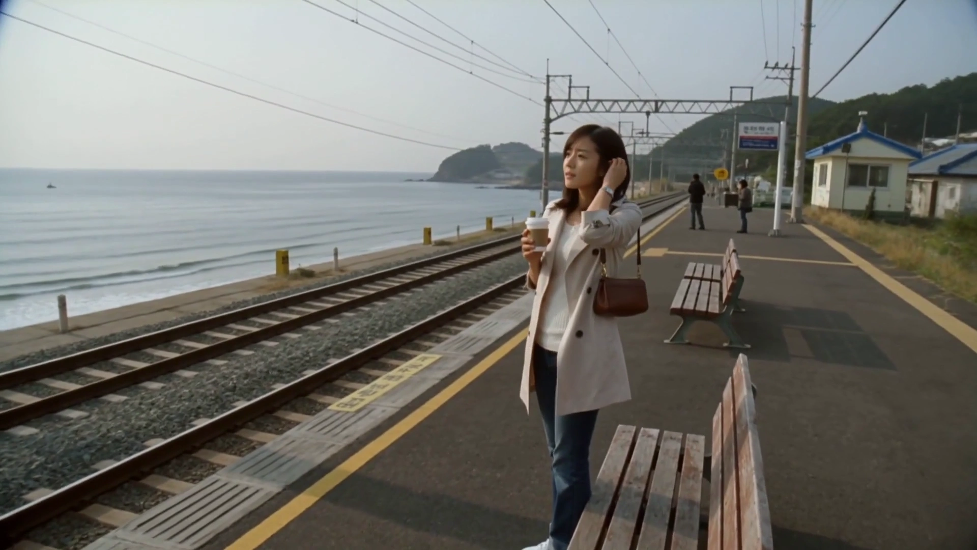 Autumn 2004: A Woman's Serene Wait at a Seaside Train Stop