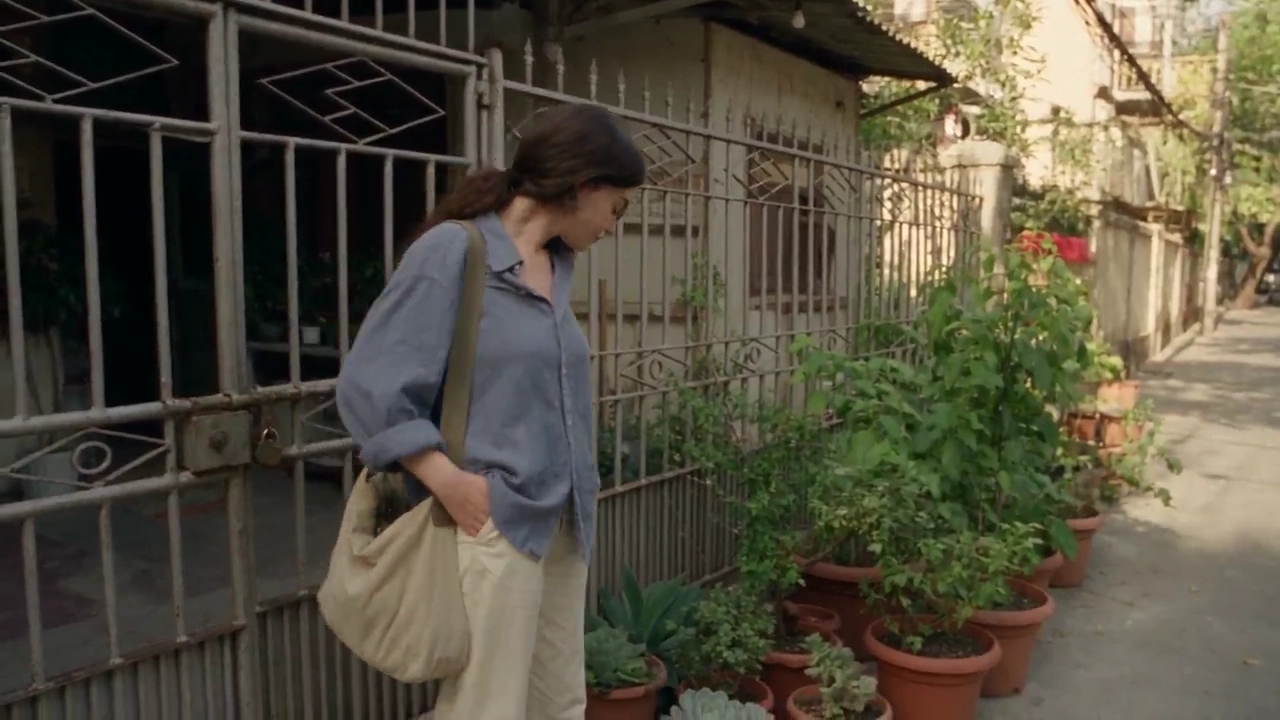 She Strolls Past Old Gates and Laundry in Soft Morning Light