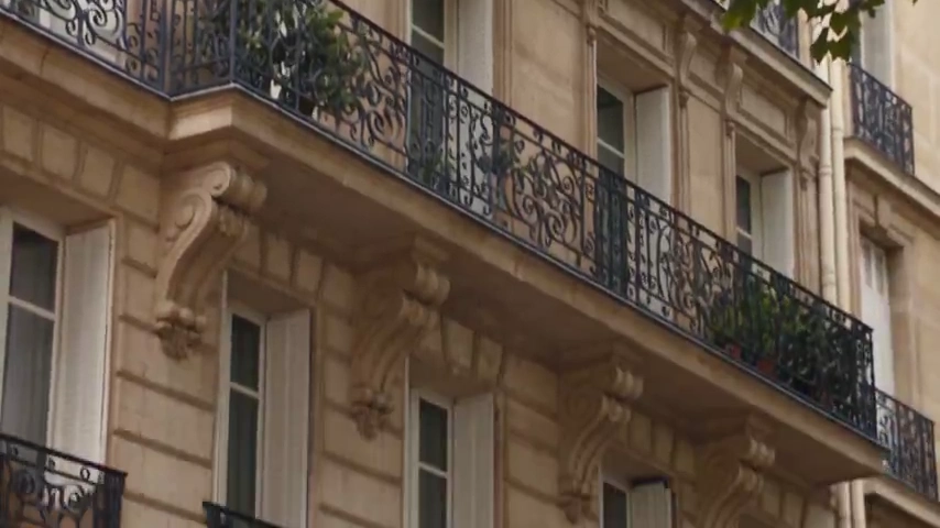 Silk Scarf Flutters as Woman Walks Paris Streets with Iconic Bag
