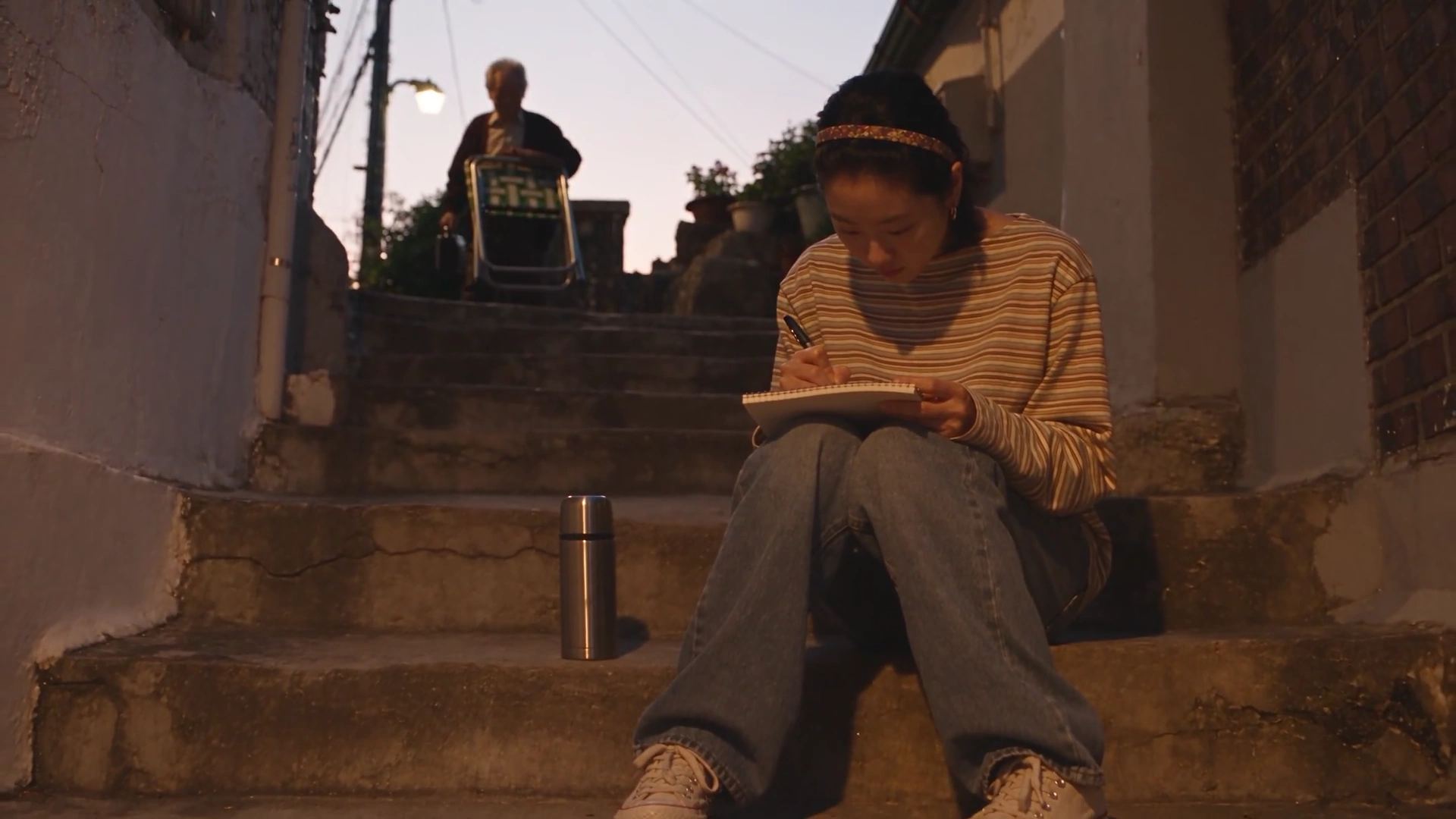 Golden Light Fades as a Woman Helps an Elderly Neighbor