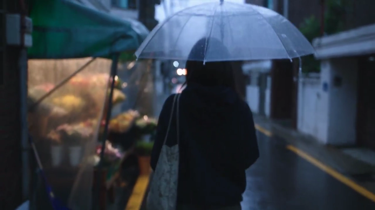 She Walks Through Rain, Finds a Small Bouquet, Smiles Softly