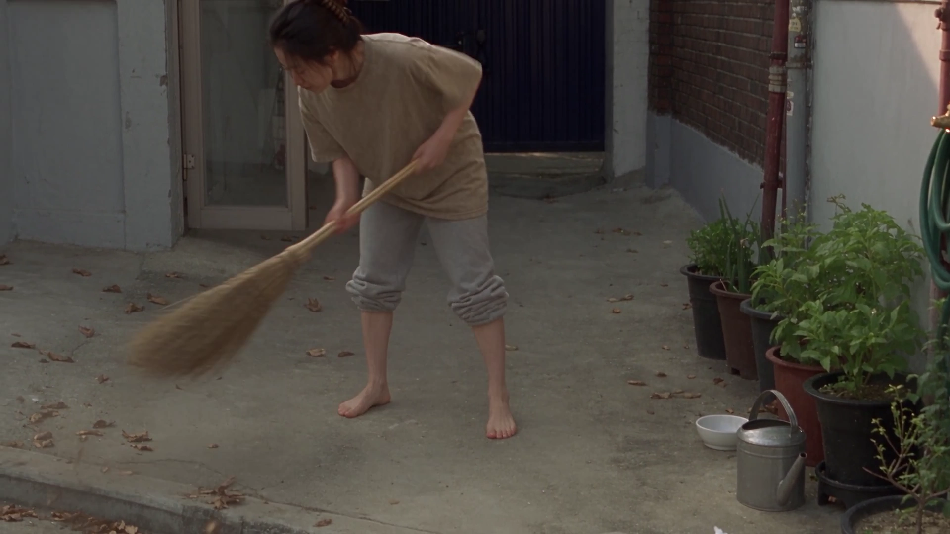 She Sweeps, Waters, and Smiles in a Faded Lo-Fi Home Video