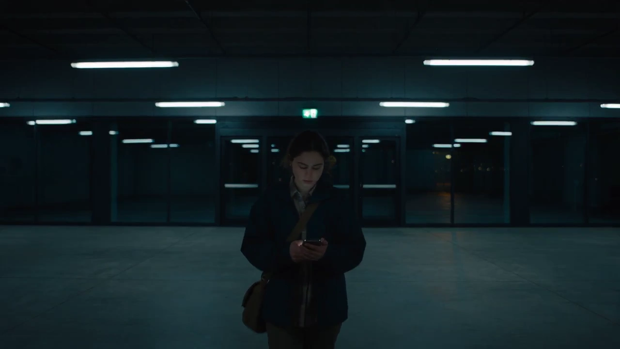 Fleeing Figure Dashes Under Red Emergency Lights in Dark Hallway