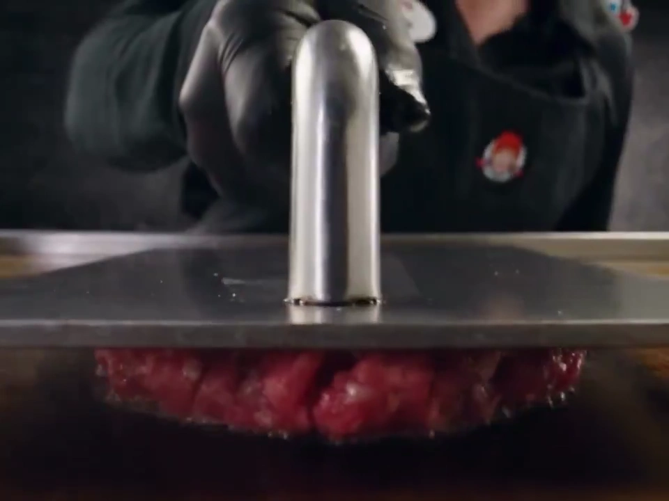 Gloved Cook Presses Sizzling Beef Patties for Wendy's Double Cheeseburger