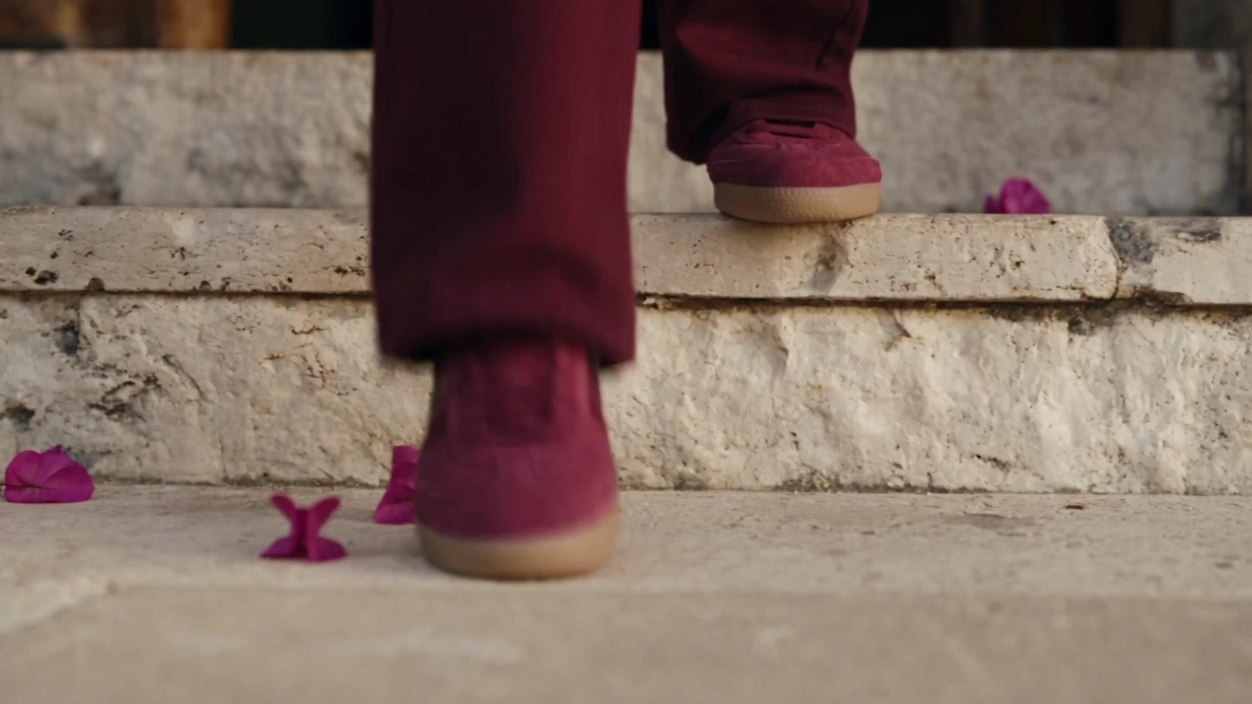 Burgundy Sneakers Stride Toward a Parked Light Green Coupe