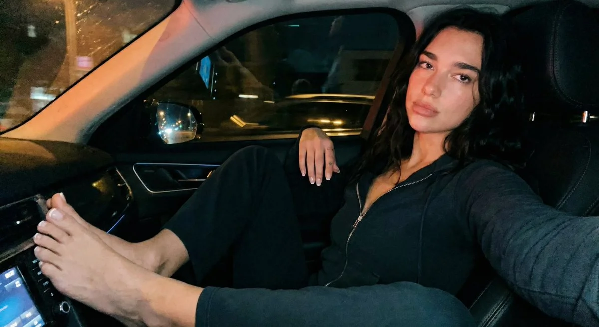 Dua Lipa's Nighttime Car Stretch in Gritty iPhone Glow