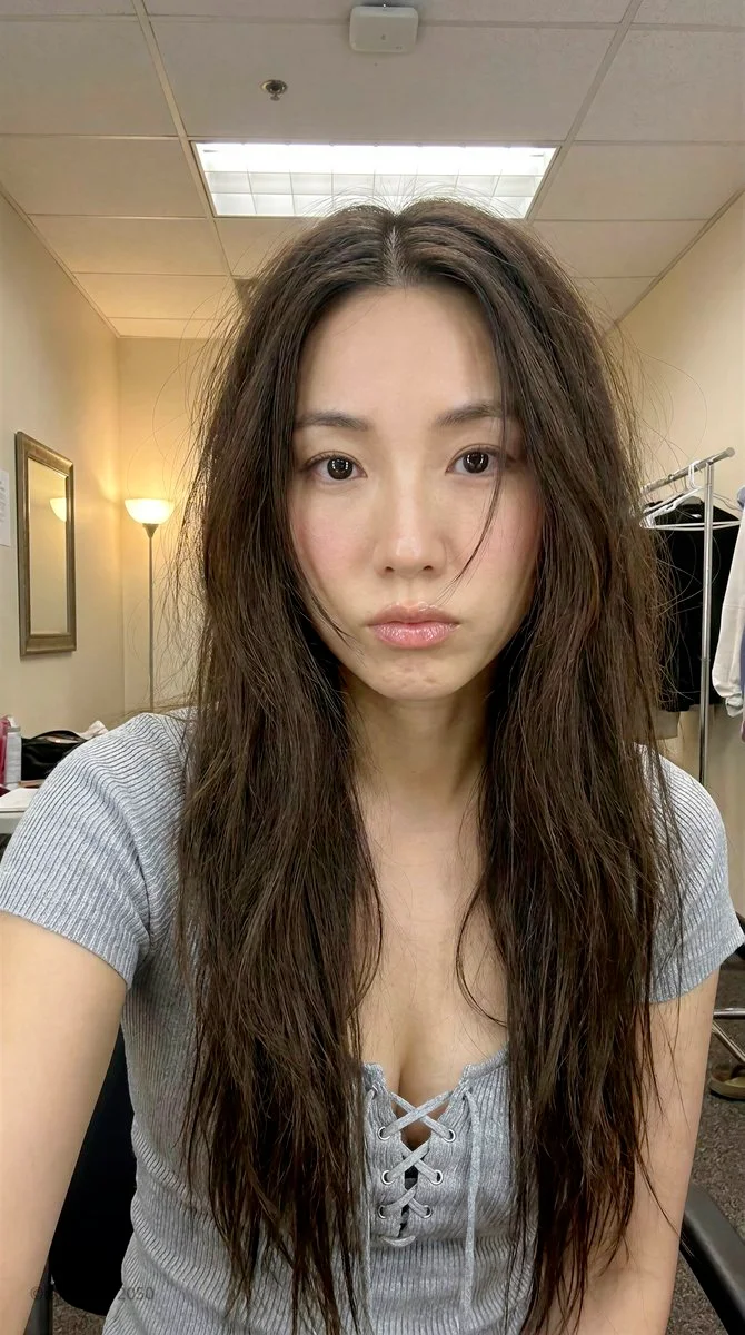 East Asian woman in dressing room with warm lamp glow