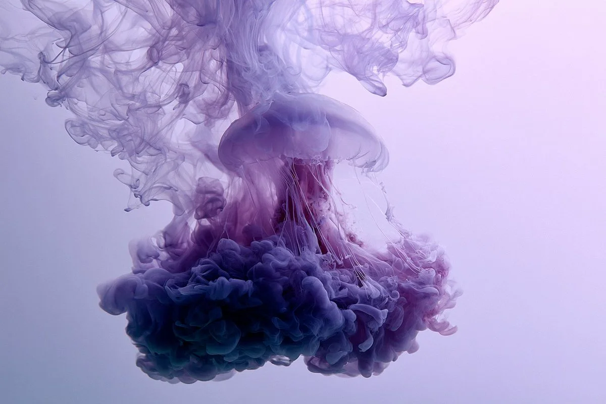 Elegant figure dissolves into swirling indigo ink underwater