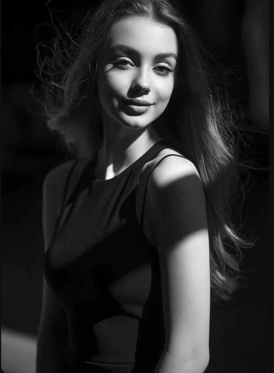 Elegant monochrome portrait captures confident gaze amid dramatic shadows