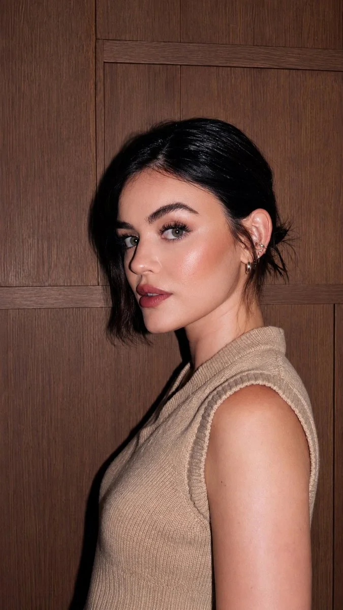 Elegant woman in beige knit poses before rich wood paneling