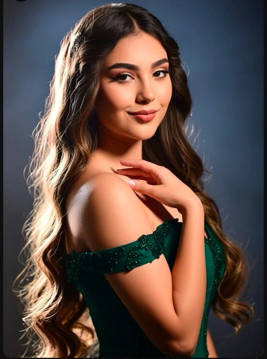 Elegant woman in emerald dress poses gracefully with a subtle smile