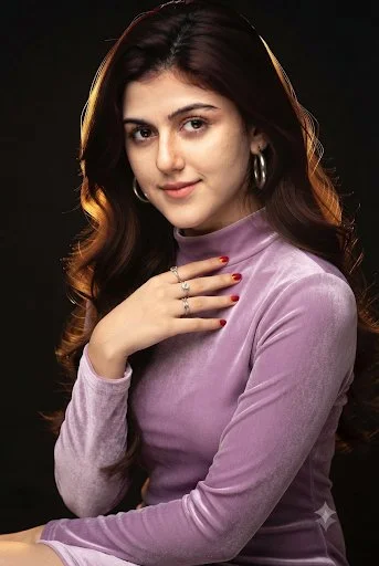 Elegant woman in velvet dress glows with golden rim light