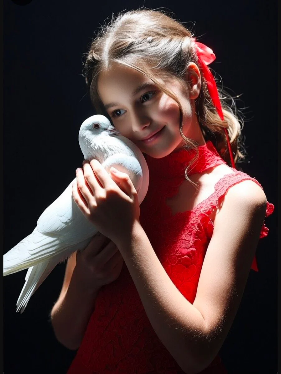 Girl in red dress holds a dove with tender serenity