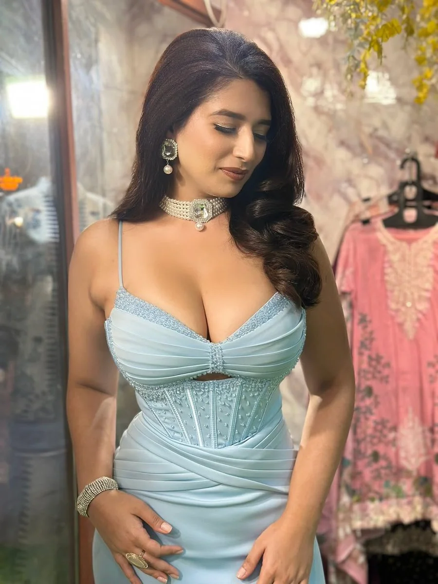 Glamorous lady with cascading dark waves wears silver jewelry