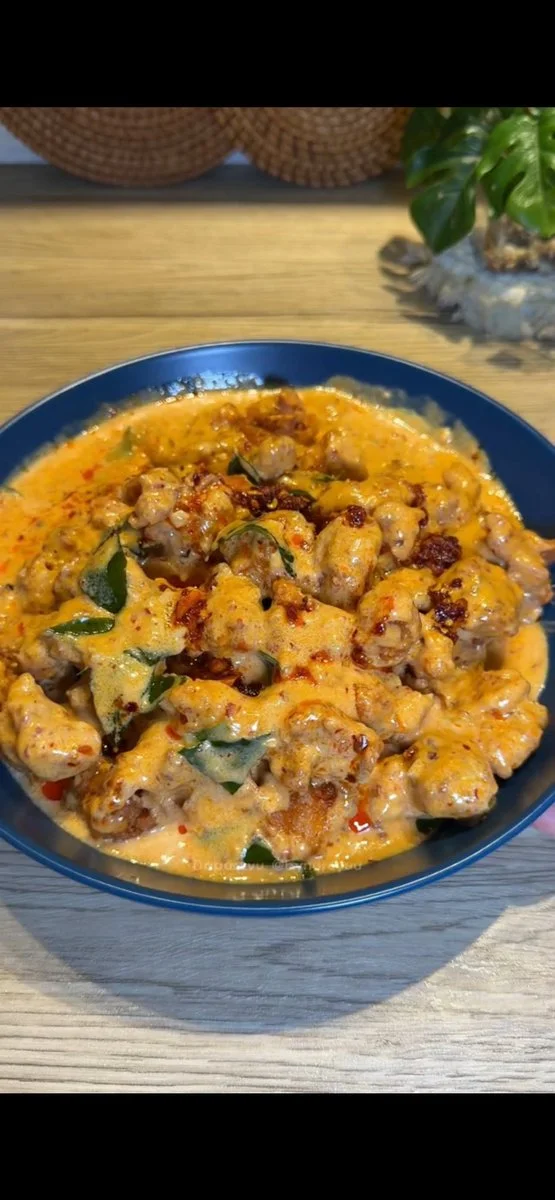Golden Chicken Pieces Glow in Deep Blue Bowl with Chili Sauce