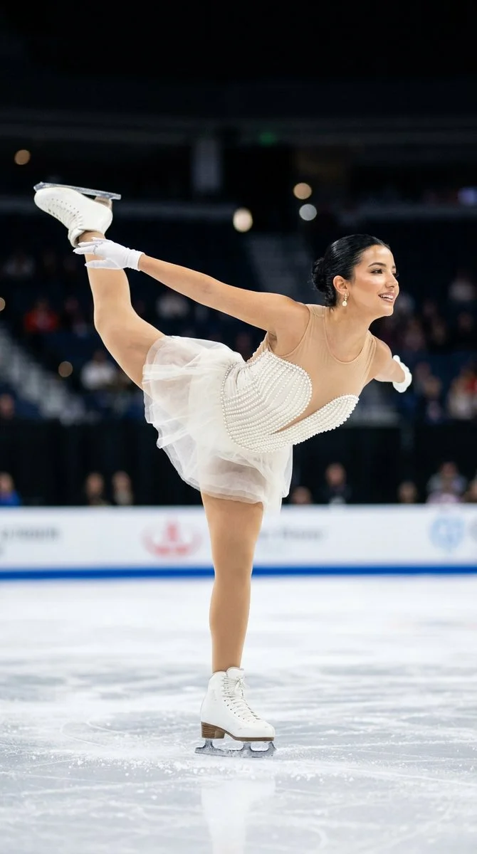 Graceful figure skater extends her leg in a powerful arabesque glide