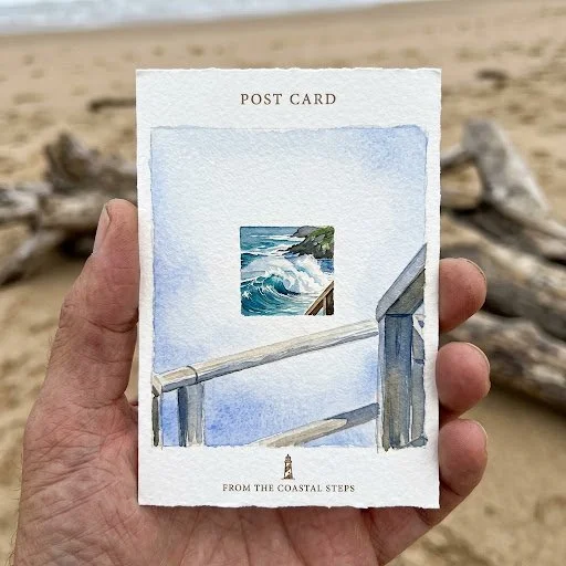 Hand Holds Watercolor Postcard of Coastal Steps by the Sea