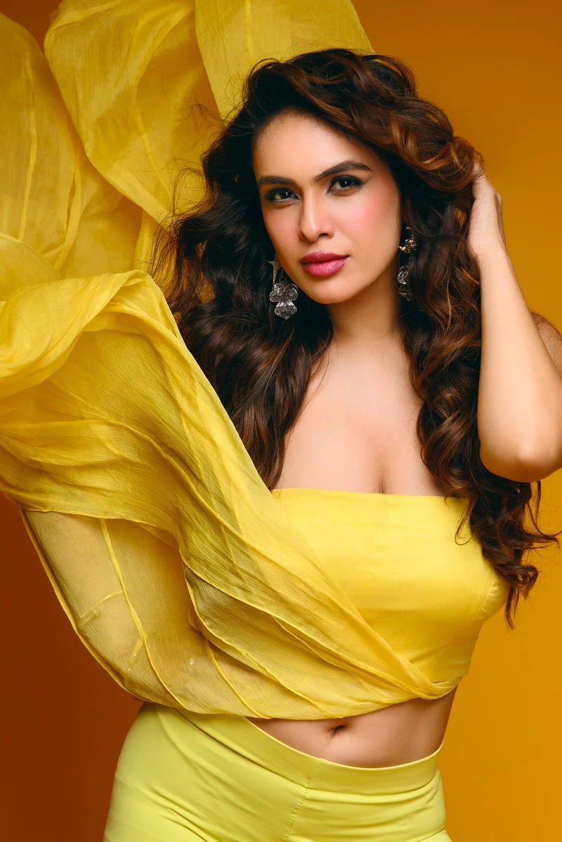 Indian model in yellow skirt and crop top poses confidently
