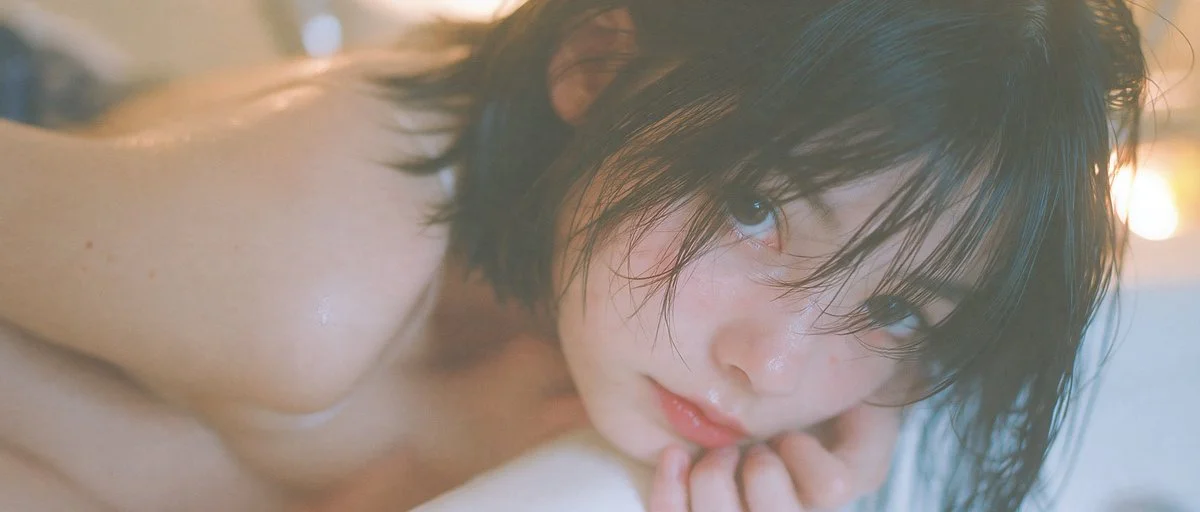 Intimate bathtub portrait bathed in warm amber flash