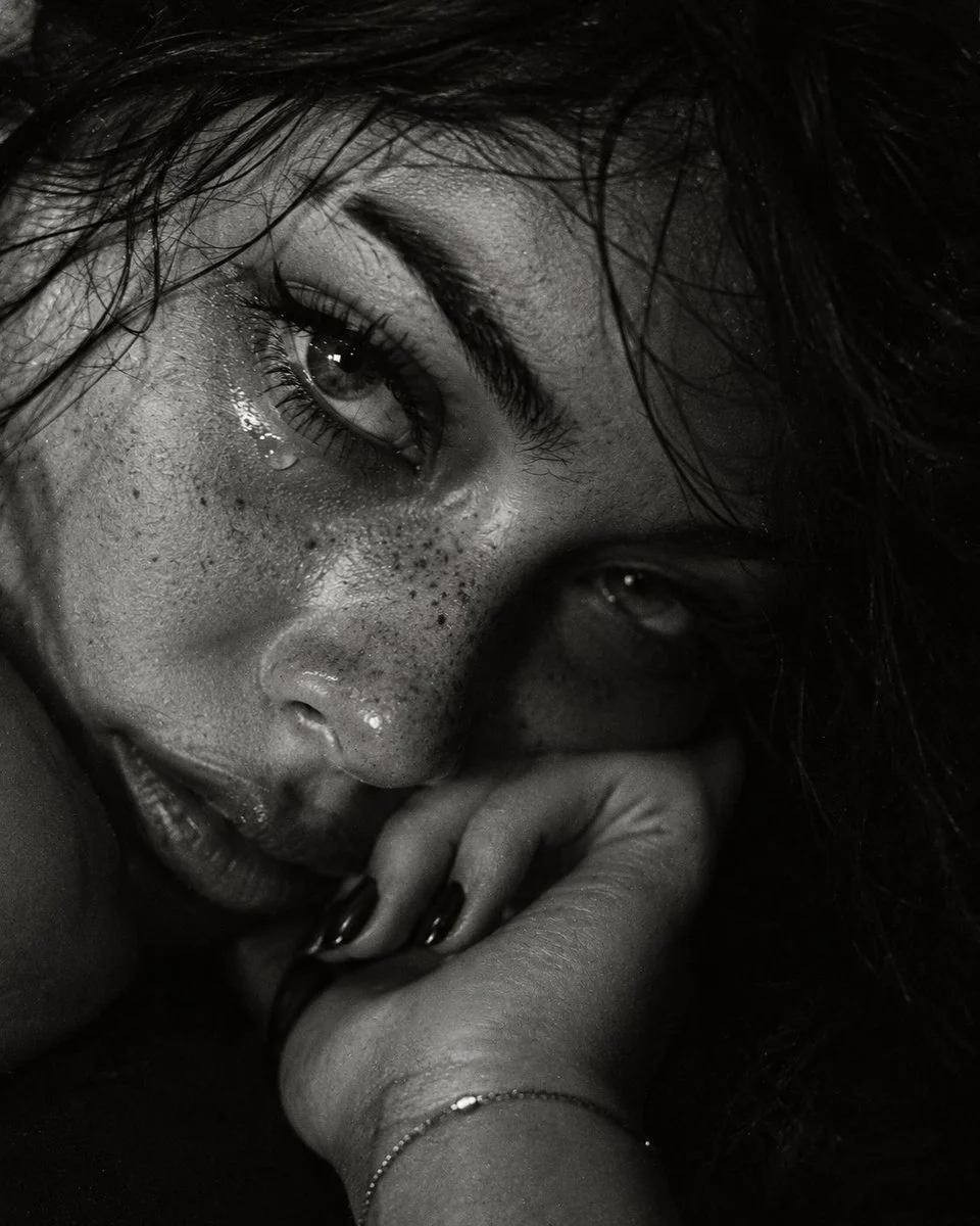 Intimate Black and White Portrait Captures Woman's Tearful Gaze in Shadow