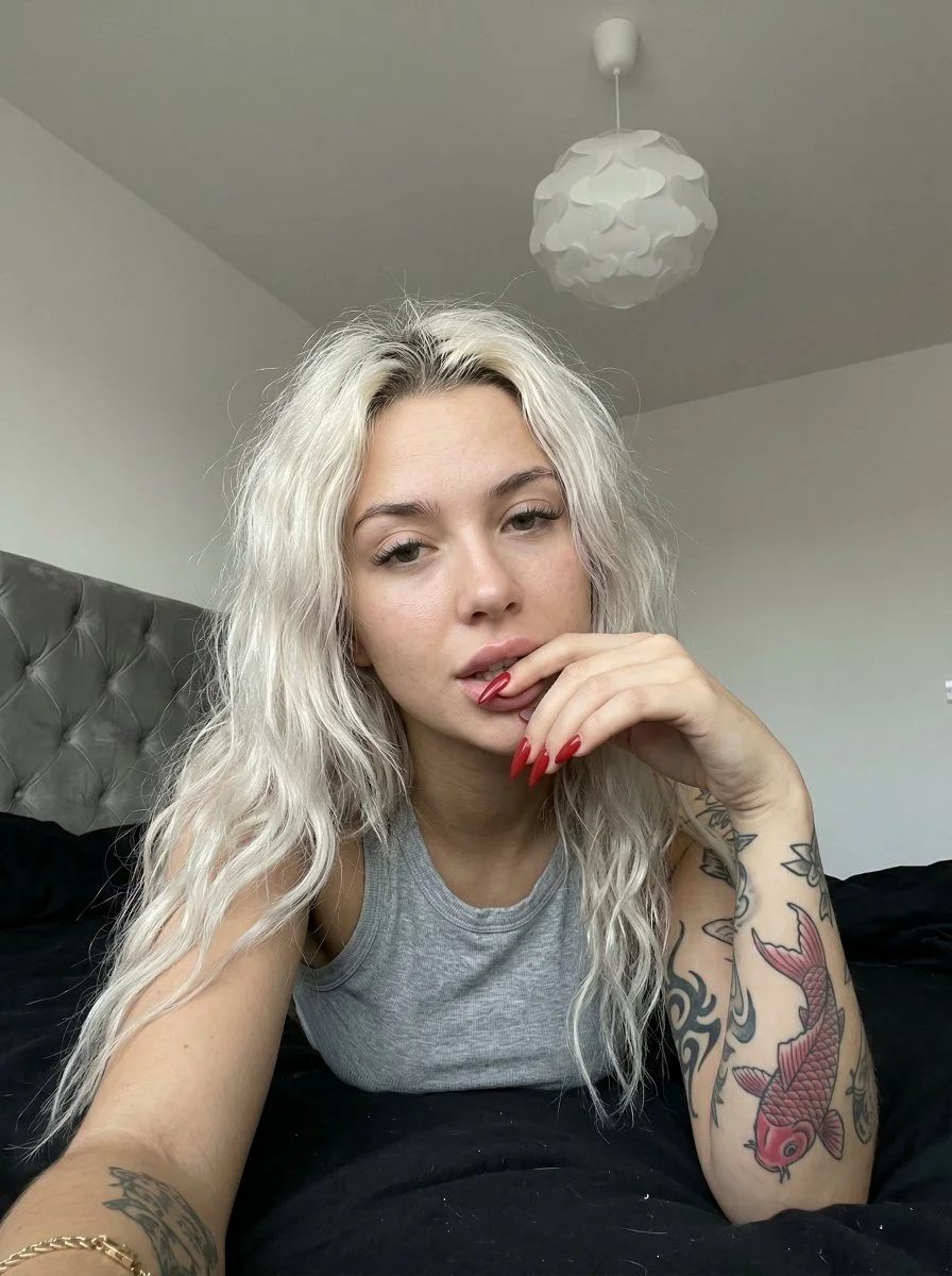 Intimate Snapshot of a Tattooed Woman in a Casual Bedroom Setting