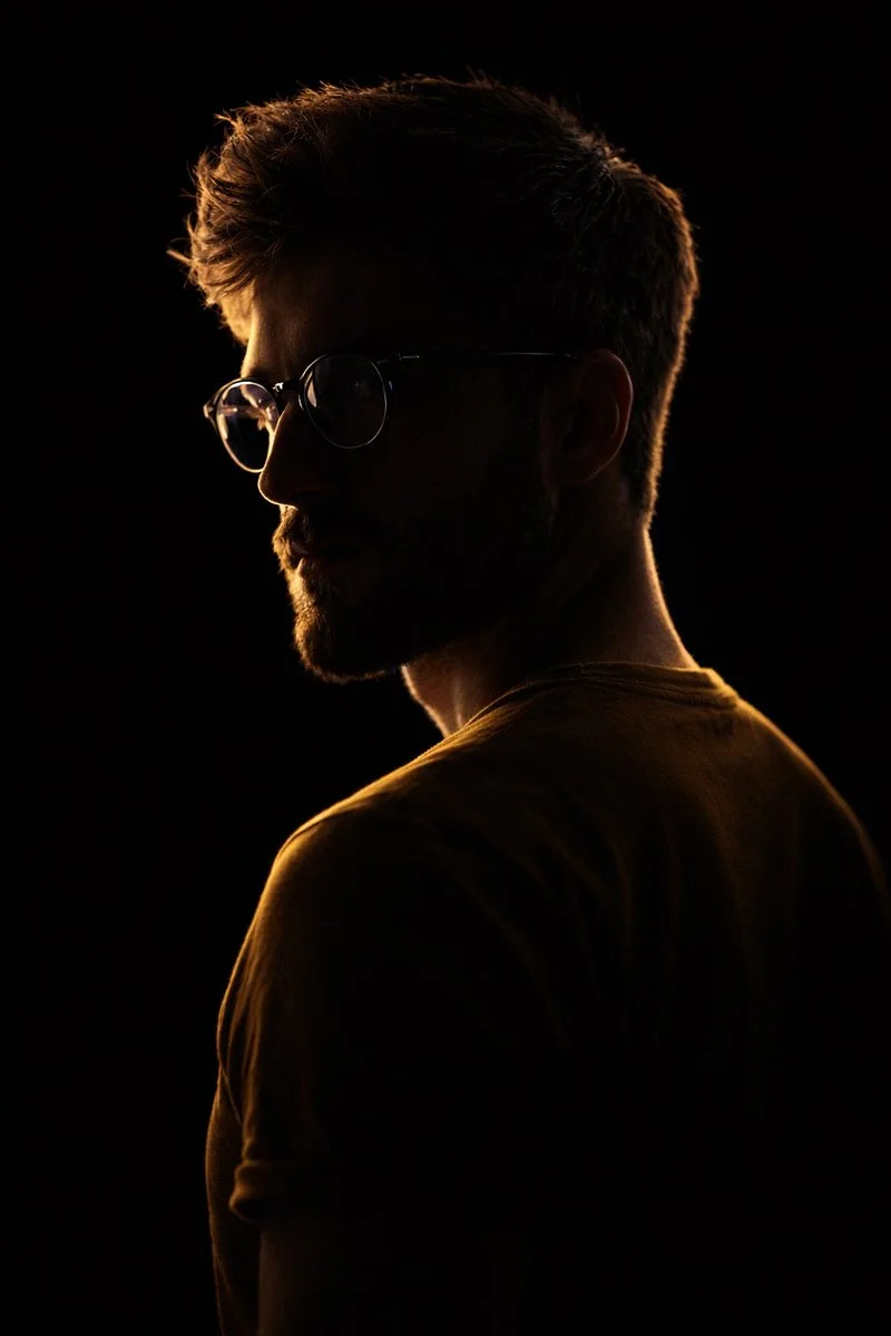 Introspective Silhouette with Warm Highlights and Reflective Eyewear