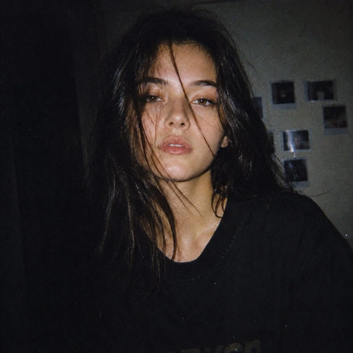 Japanese woman with pale skin stares calmly in dim flash snapshot