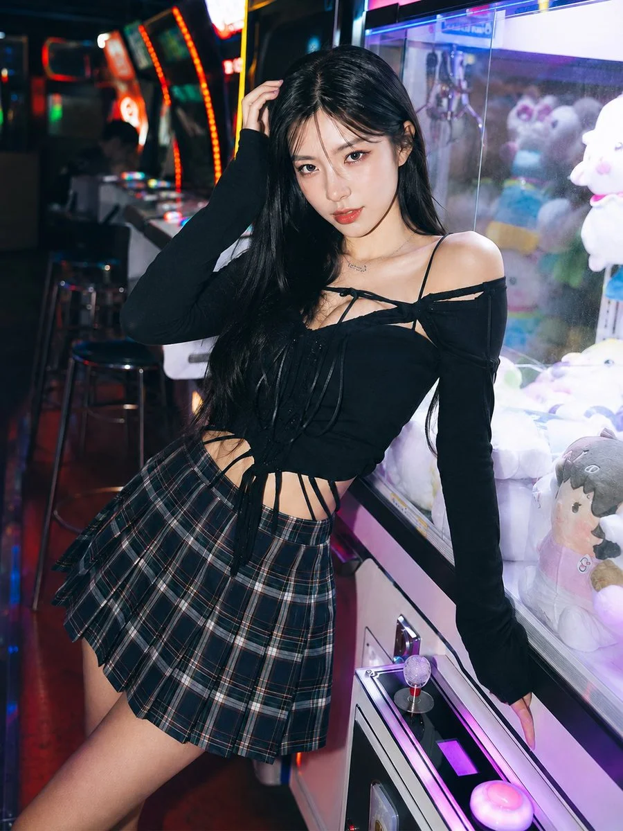 Korean woman leans on claw machine under neon lights