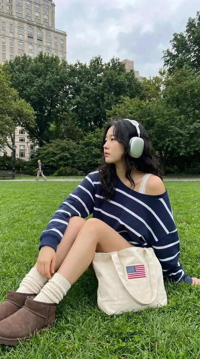 Korean woman listens to music in Central Park with headphones