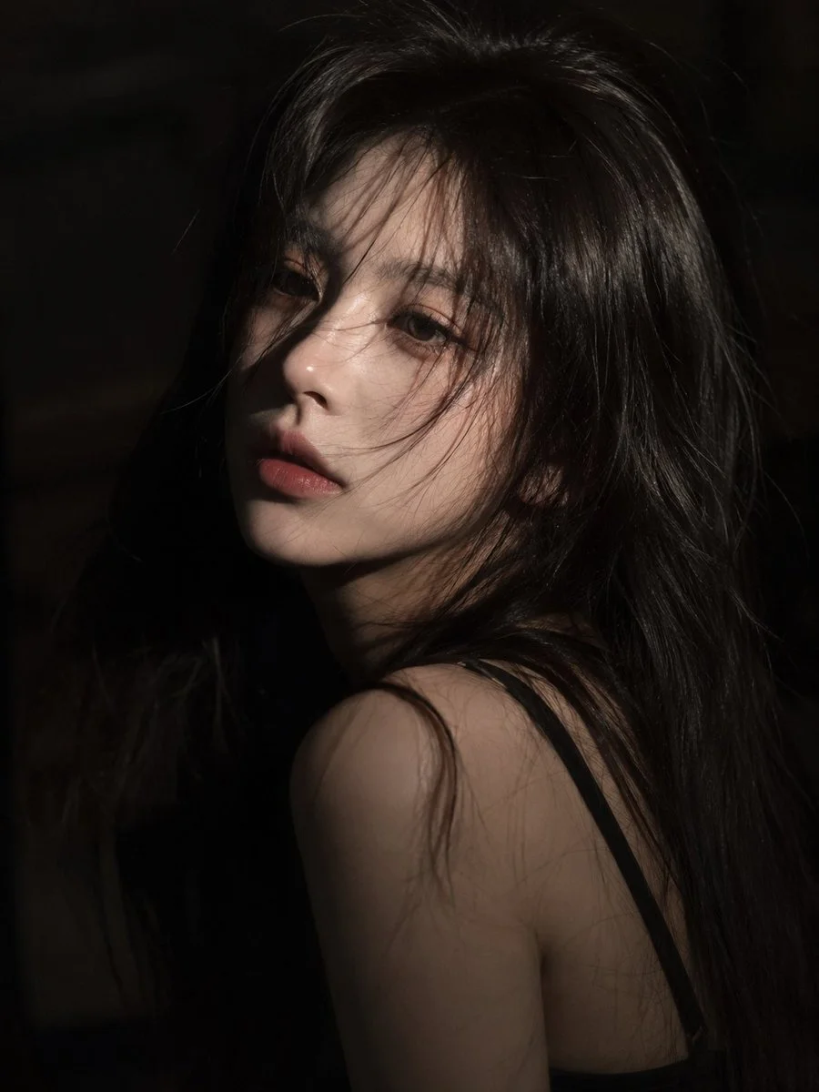 Melancholic woman with dark hair gazes softly in cinematic light