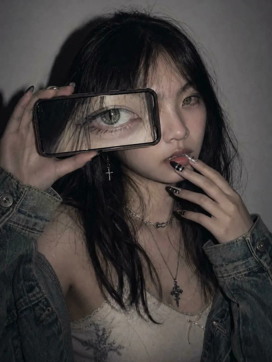 Model's playful mirror selfie showcases branded jacket in modern bathroom