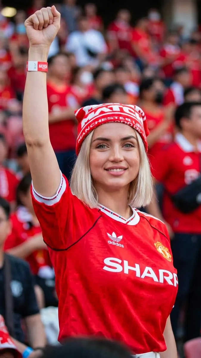 Red jersey gleams under sunlight at Old Trafford stadium