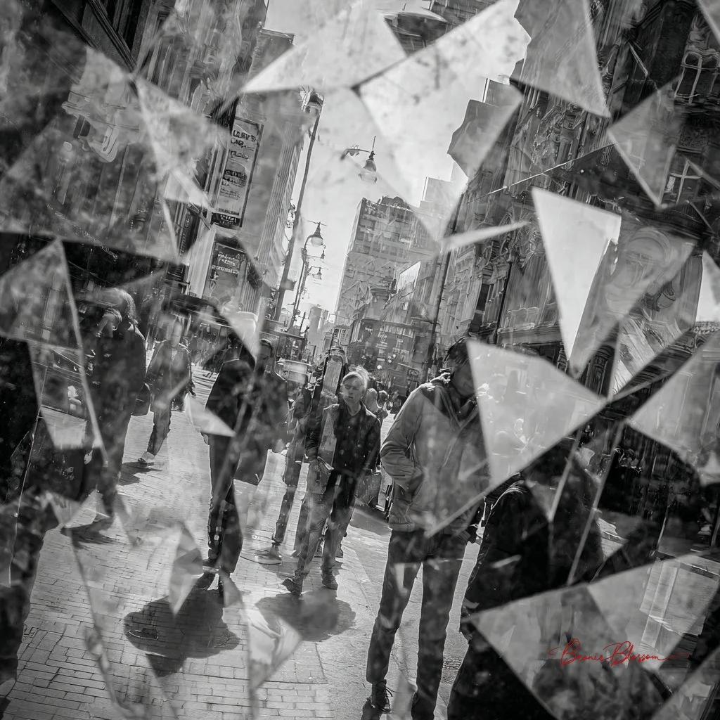 Shattered mirror shows fractured city street and people