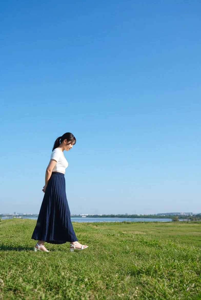 Side-profile stroll: white crop top and navy pleated skirt