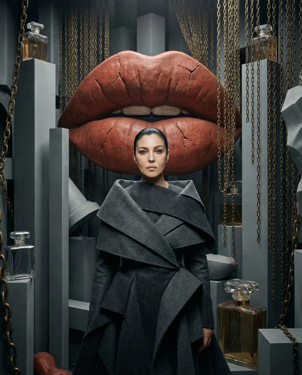 Stoic muse stands centered among surrealist sculptures and chains