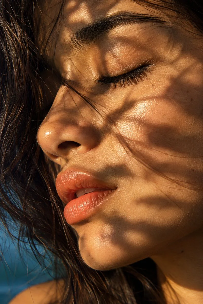 Sunlit skin reveals raw beauty in dappled shadow portrait